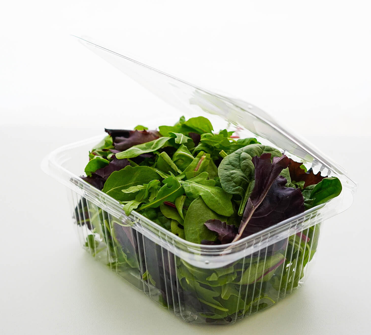 Clear plastic package containing mixed greens